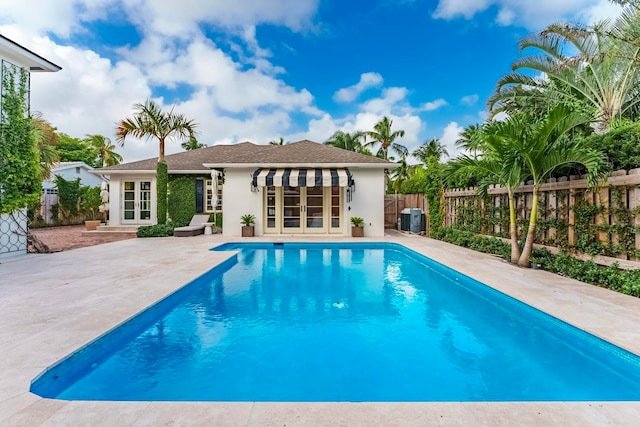 view of swimming pool with french doors and a patio