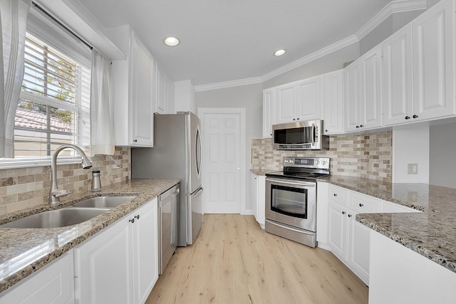 kitchen featuring decorative backsplash, white cabinets, stainless steel appliances, and light stone counters