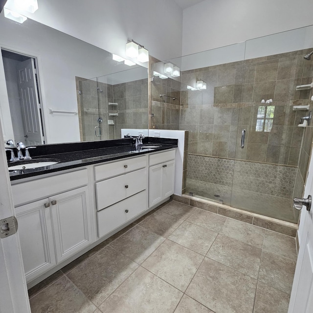 bathroom with double vanity, a stall shower, and a sink