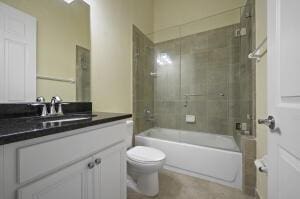 bathroom featuring toilet,  shower combination, and vanity