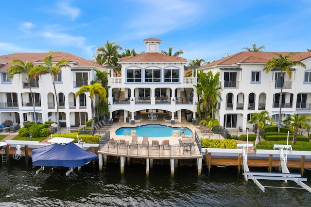 rear view of property featuring a water view, a patio, and a balcony