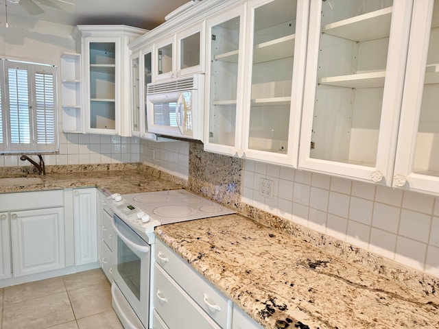 kitchen with white cabinets, tasteful backsplash, sink, and white appliances