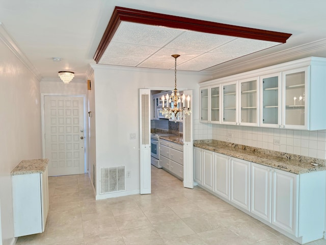 kitchen with electric range, decorative light fixtures, ornamental molding, backsplash, and white cabinets