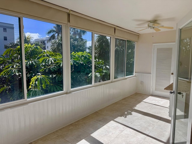 unfurnished sunroom featuring a healthy amount of sunlight and ceiling fan