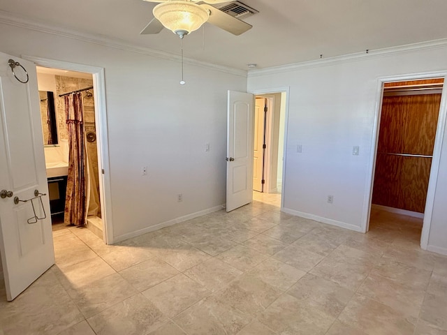 unfurnished bedroom featuring connected bathroom, a walk in closet, ornamental molding, a closet, and ceiling fan