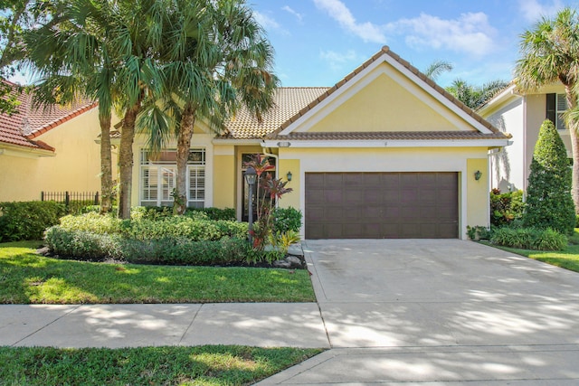 mediterranean / spanish home with a front yard and a garage