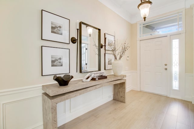 entryway featuring crown molding and light wood-type flooring