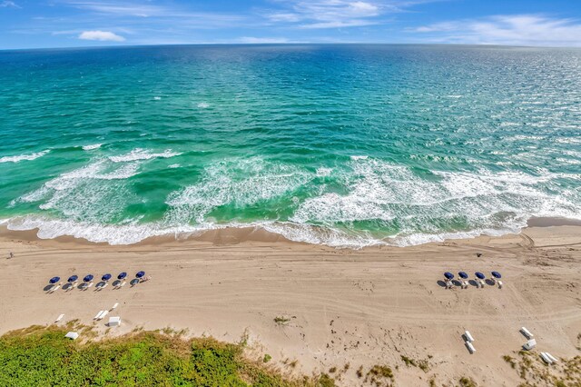 birds eye view of property featuring a water view and a beach view