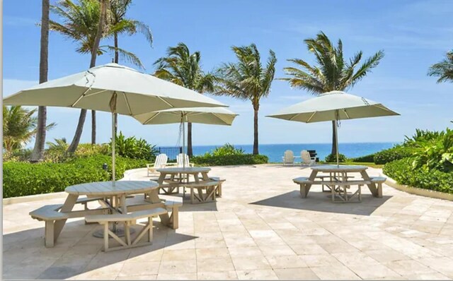 view of home's community with a water view, a patio area, and outdoor dining area