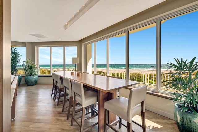 sunroom with a beach view, visible vents, and a water view