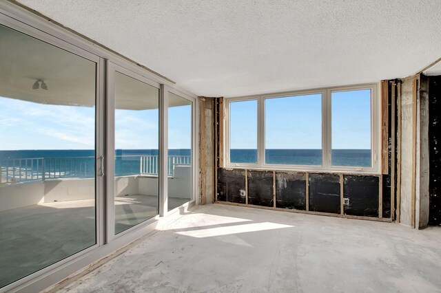 unfurnished sunroom featuring a water view