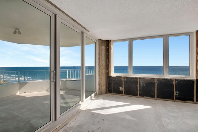 unfurnished sunroom with a water view