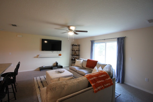 carpeted living room with ceiling fan and a textured ceiling