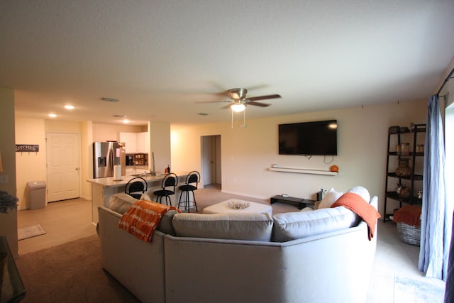 carpeted living room with ceiling fan