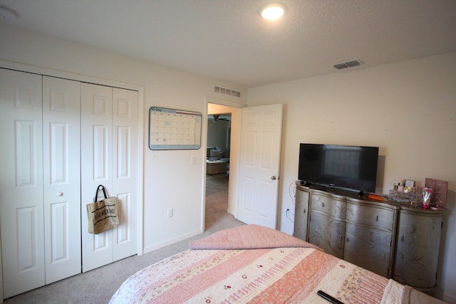 bedroom featuring light colored carpet and a closet