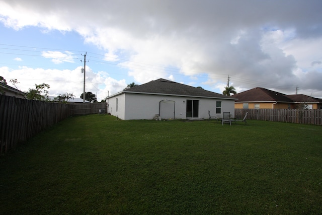 rear view of house featuring a yard