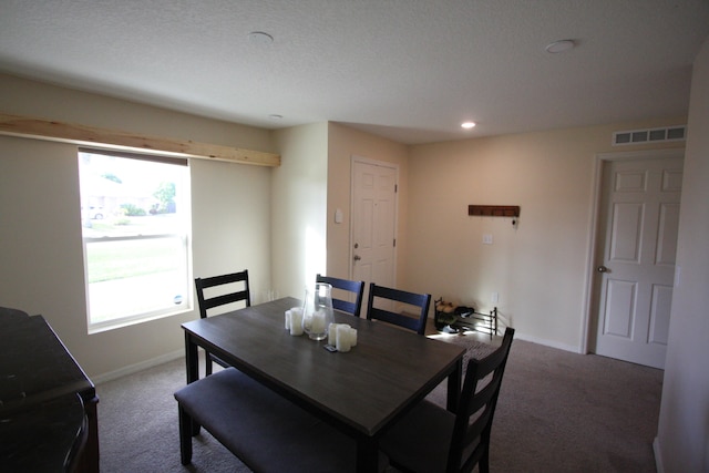 dining room featuring a textured ceiling and carpet