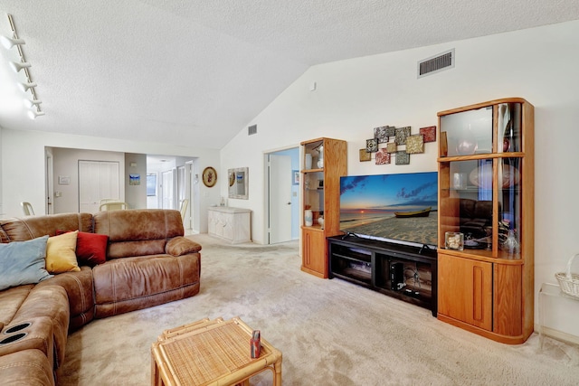 carpeted living area with visible vents, a textured ceiling, and vaulted ceiling