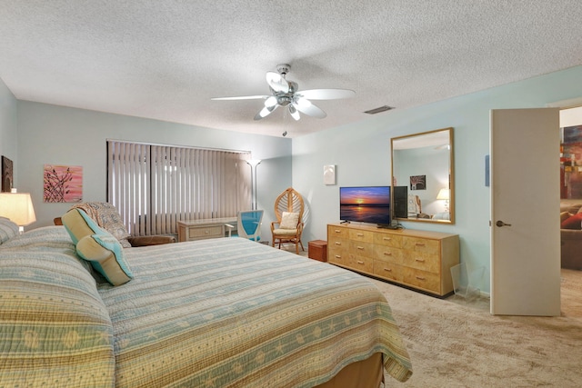 bedroom with visible vents, carpet, ceiling fan, and a textured ceiling