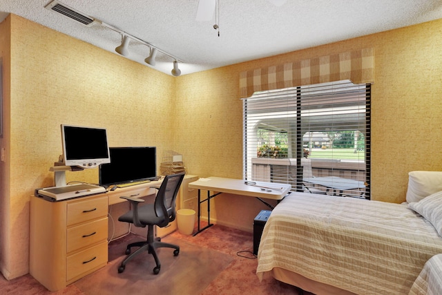 carpeted bedroom with visible vents, a textured ceiling, and wallpapered walls