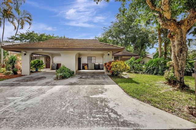 view of front of home featuring stucco siding, a carport, concrete driveway, and a tile roof