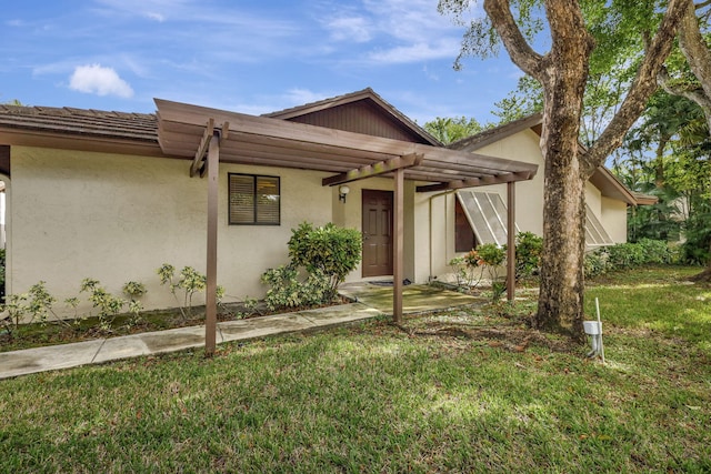 view of front of property featuring a front lawn and stucco siding