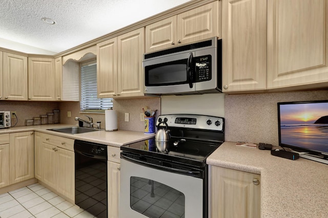 kitchen with light tile patterned floors, a sink, stainless steel appliances, light countertops, and a textured ceiling