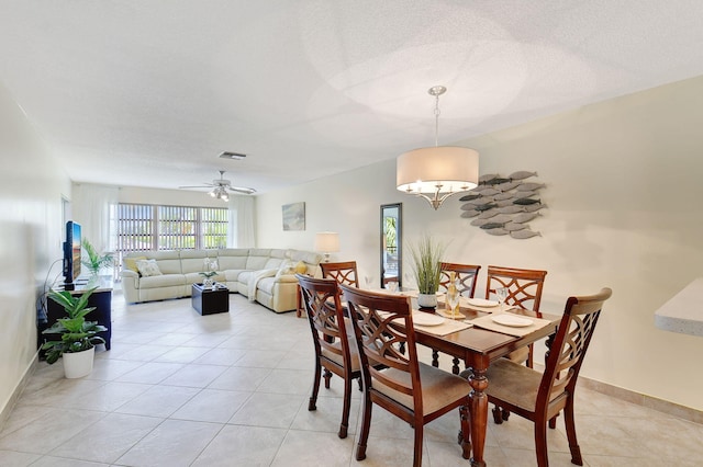 tiled dining room featuring ceiling fan and a textured ceiling