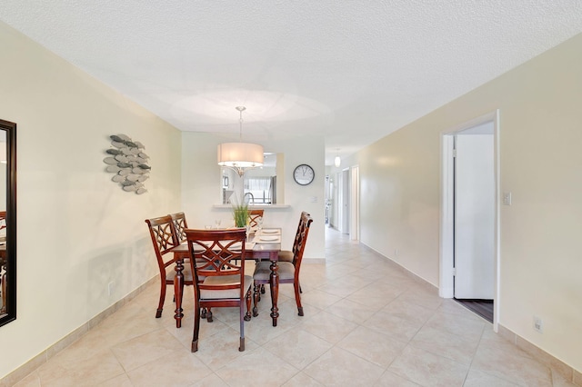 tiled dining area with a textured ceiling