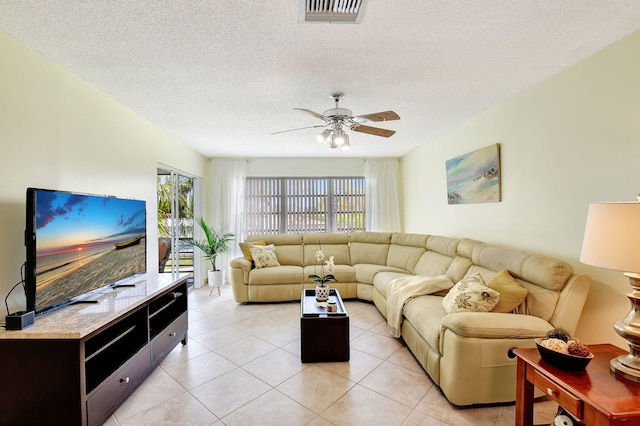 tiled living room with ceiling fan and a textured ceiling