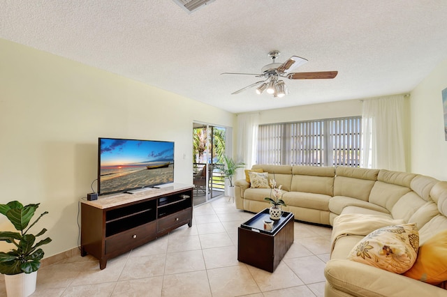 living room with a textured ceiling, light tile patterned floors, and ceiling fan