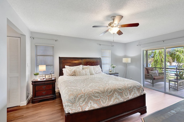 bedroom with a closet, access to outside, ceiling fan, and light wood-type flooring