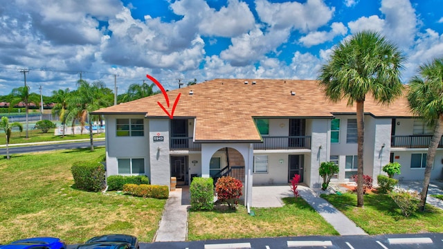 townhome / multi-family property with a front yard and a balcony