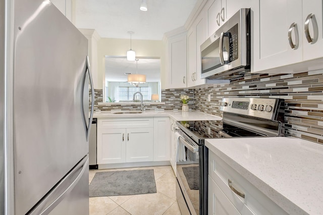 kitchen with tasteful backsplash, pendant lighting, white cabinets, and stainless steel appliances