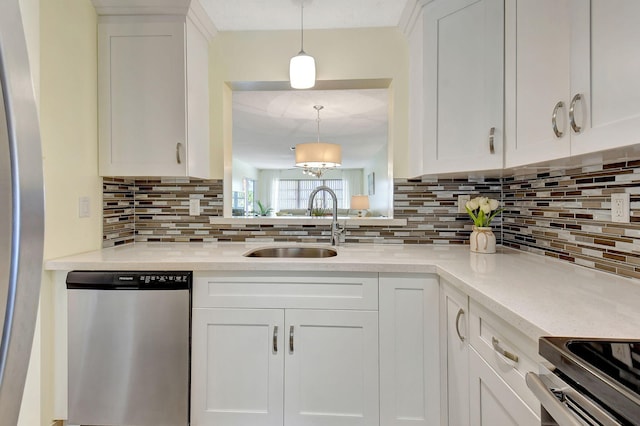 kitchen with white cabinetry, decorative backsplash, appliances with stainless steel finishes, and pendant lighting