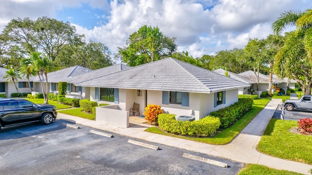 212 Club Dr, Palm Beach Gardens, FL 33418 - view of front facade with stucco siding, uncovered parking, a front yard, cooling unit, and a tiled roof