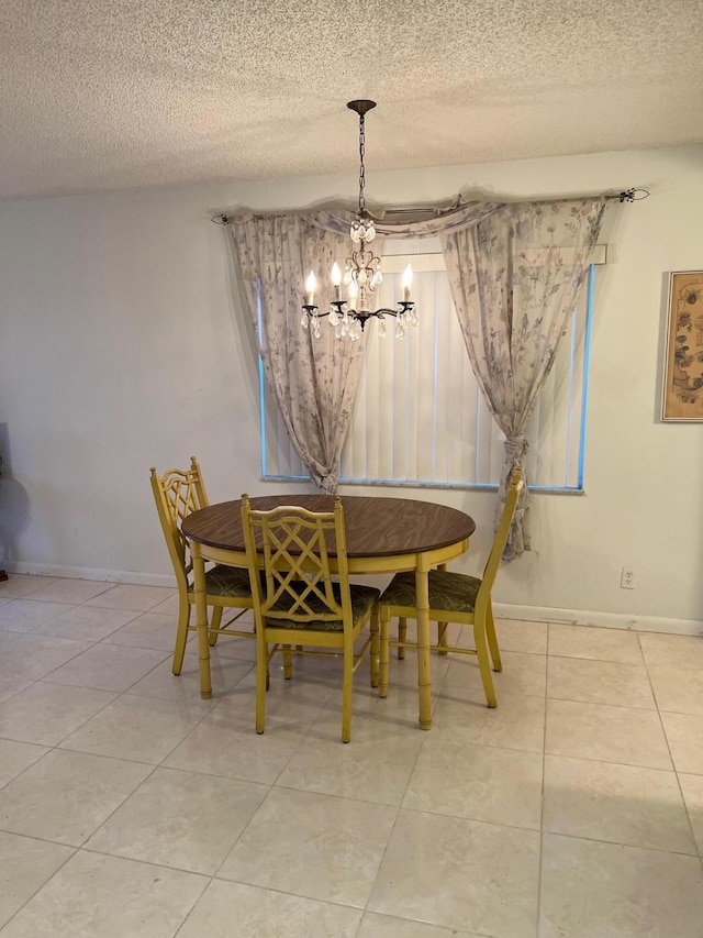 tiled dining area featuring a notable chandelier and a textured ceiling