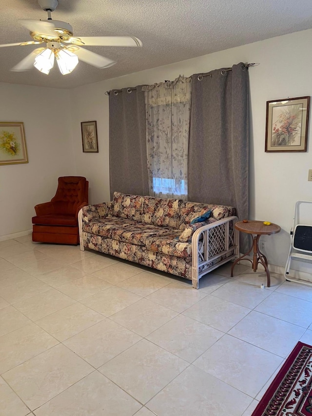 living room featuring a textured ceiling, light tile patterned flooring, and ceiling fan