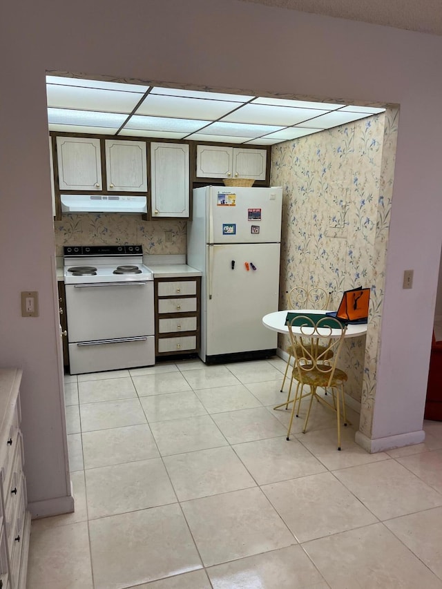 kitchen featuring white appliances, decorative backsplash, and light tile patterned floors