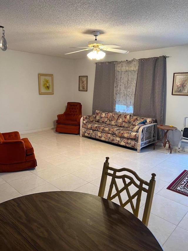 living room with a textured ceiling, tile patterned floors, and ceiling fan