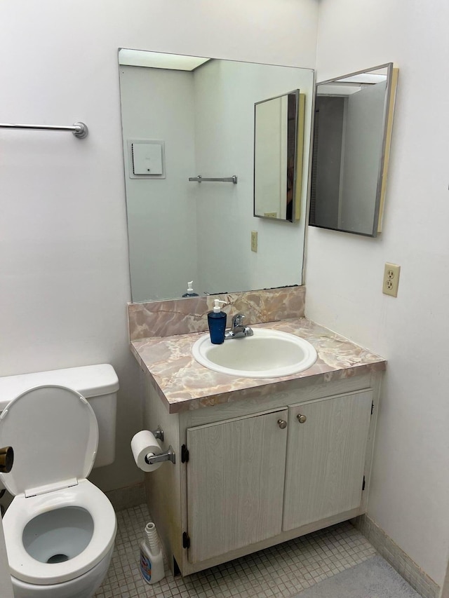 bathroom with vanity, toilet, and tile patterned flooring