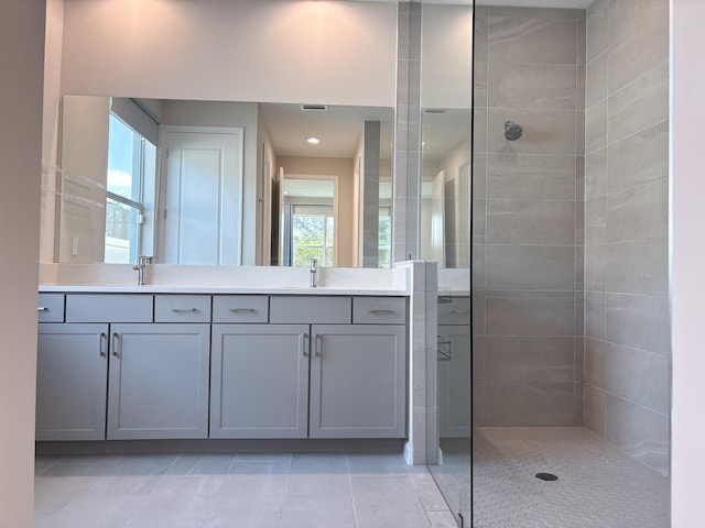 bathroom with a tile shower, plenty of natural light, and vanity