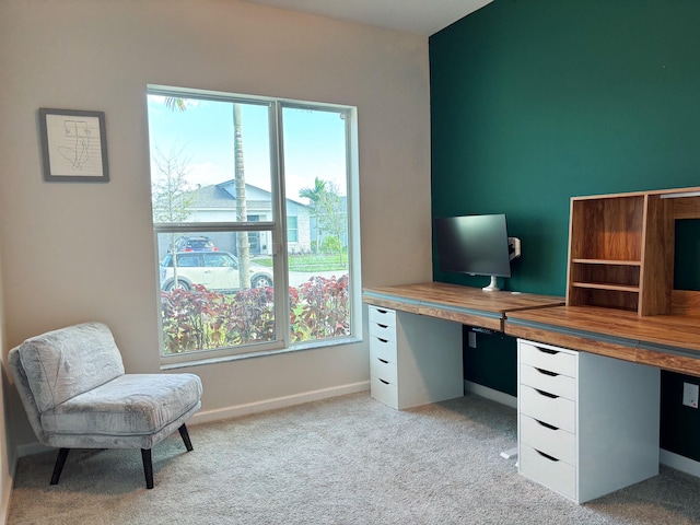 carpeted office with plenty of natural light and built in desk