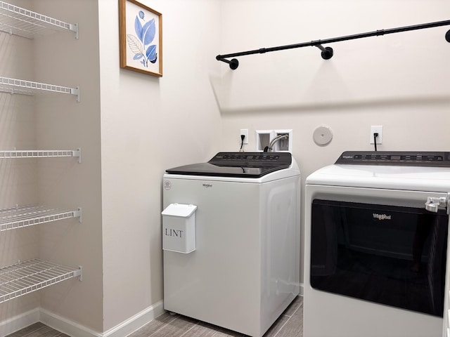 laundry area featuring independent washer and dryer and light hardwood / wood-style flooring