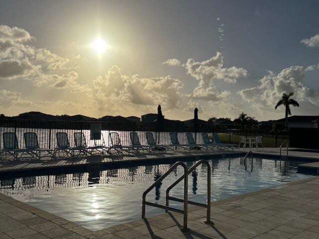 pool at dusk featuring a patio area