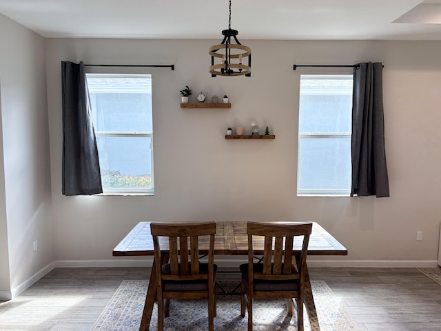 dining room with hardwood / wood-style floors and a chandelier