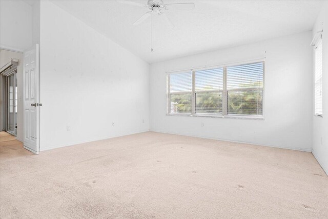 empty room with light carpet, lofted ceiling, and ceiling fan