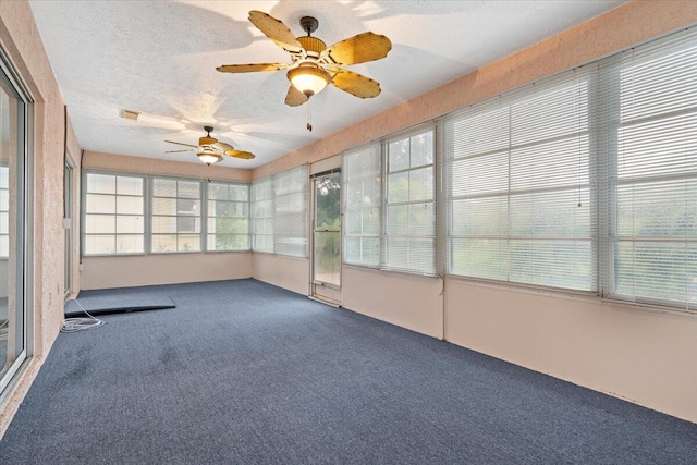 unfurnished sunroom featuring ceiling fan