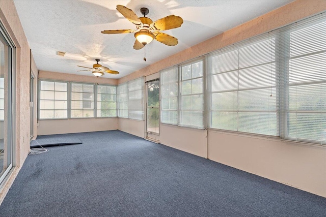 unfurnished sunroom with ceiling fan and a healthy amount of sunlight