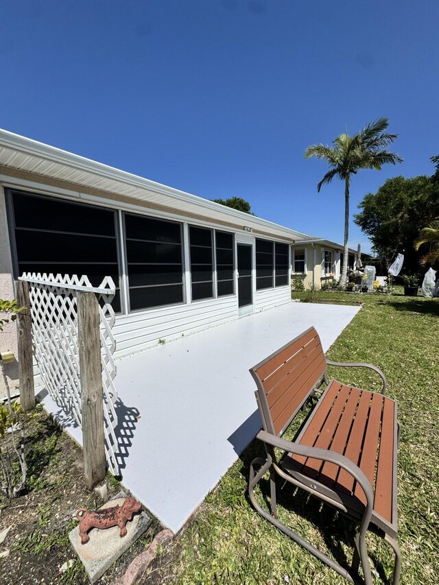 back of property with a patio and a lawn